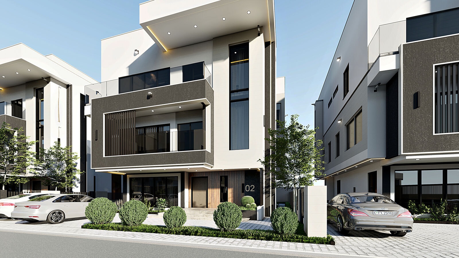 A white and charcoal duplex with a glazed balcony and planted frontage