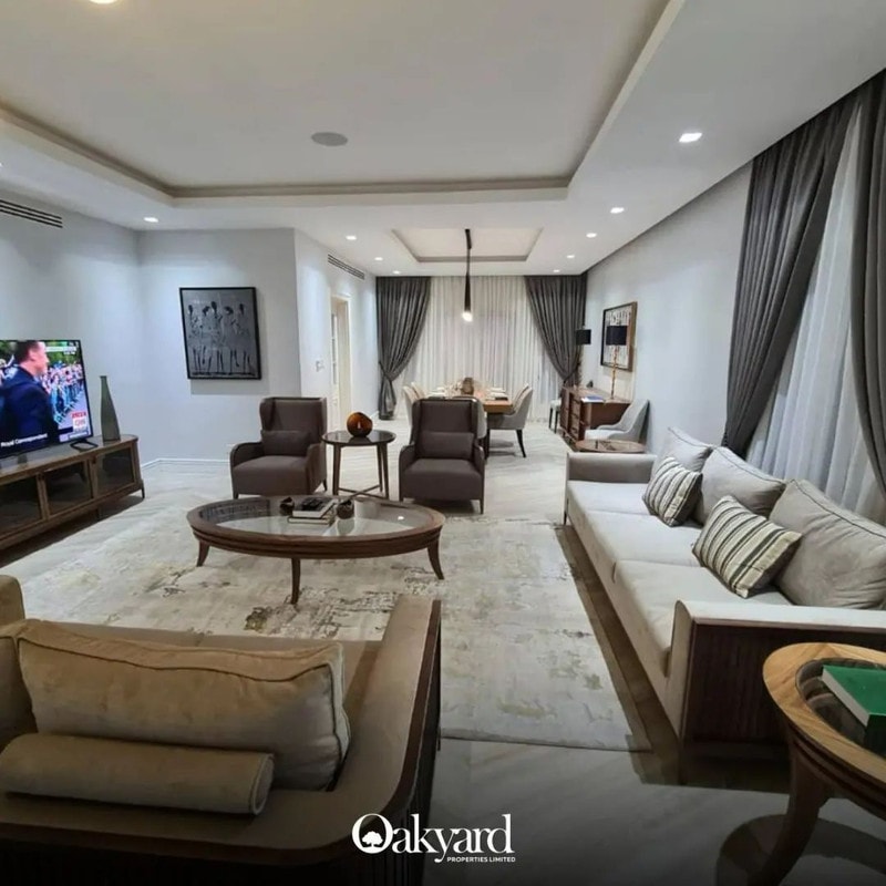 Furnished sitting room in a completed Oakyard home, opening to a dining area